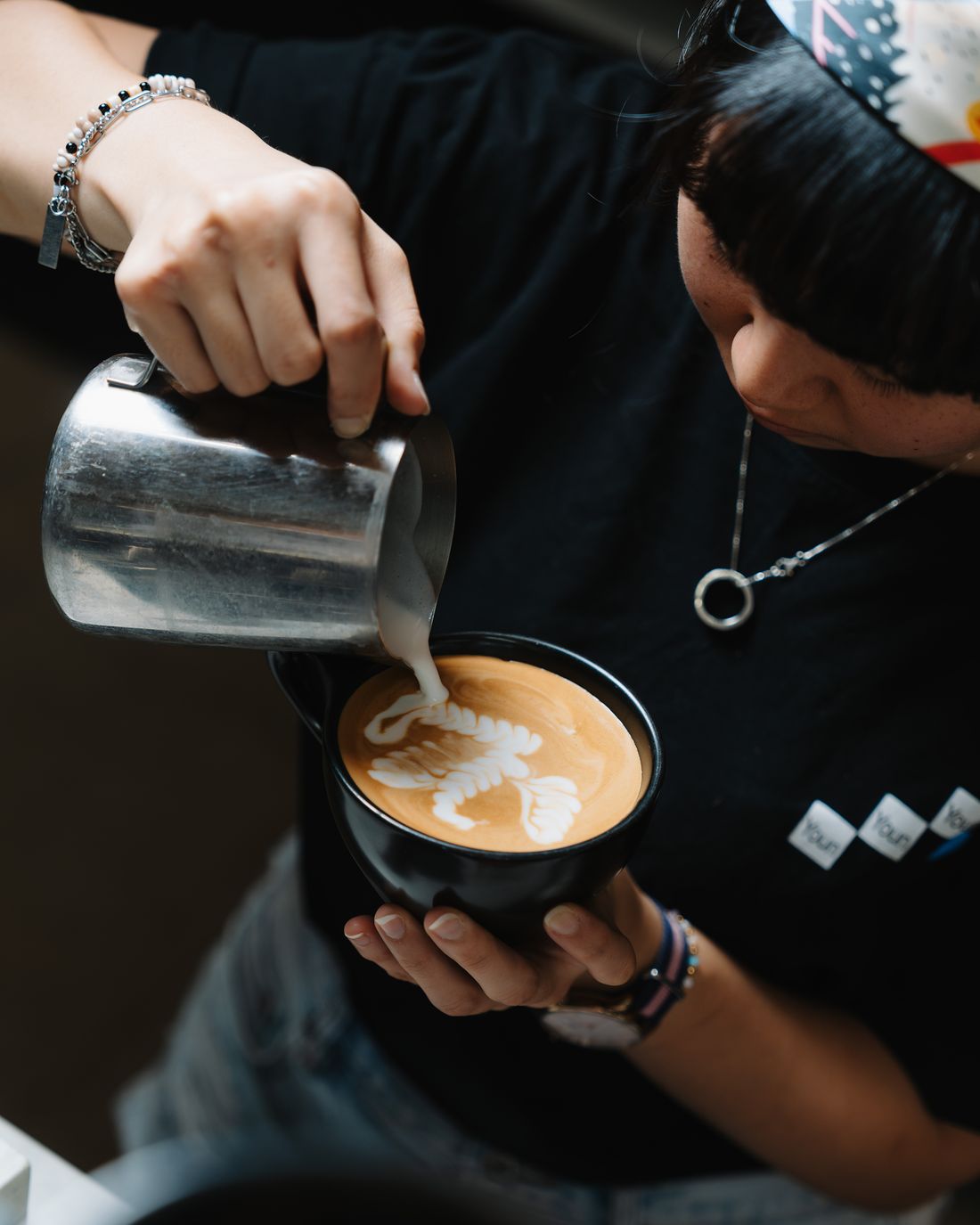 A Momento barista pouring latte art
