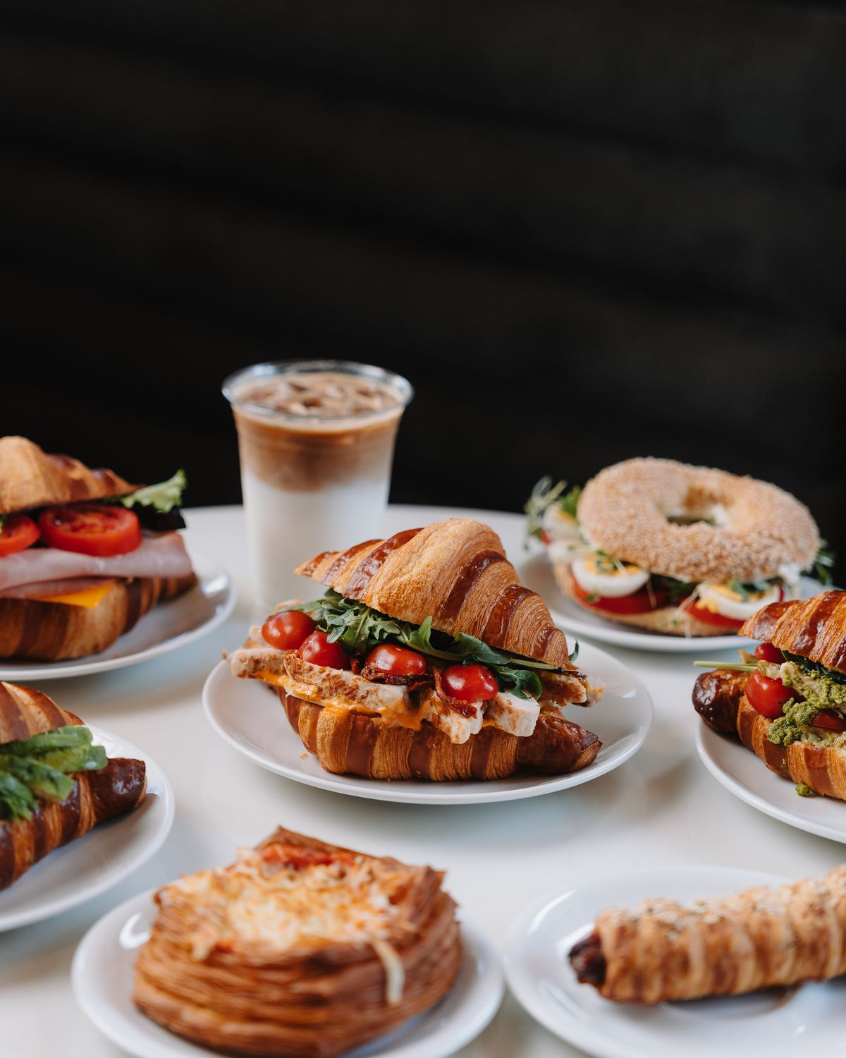 A table of croissant sandwiches, ciabattas, pastries and iced lattes at Momento Café