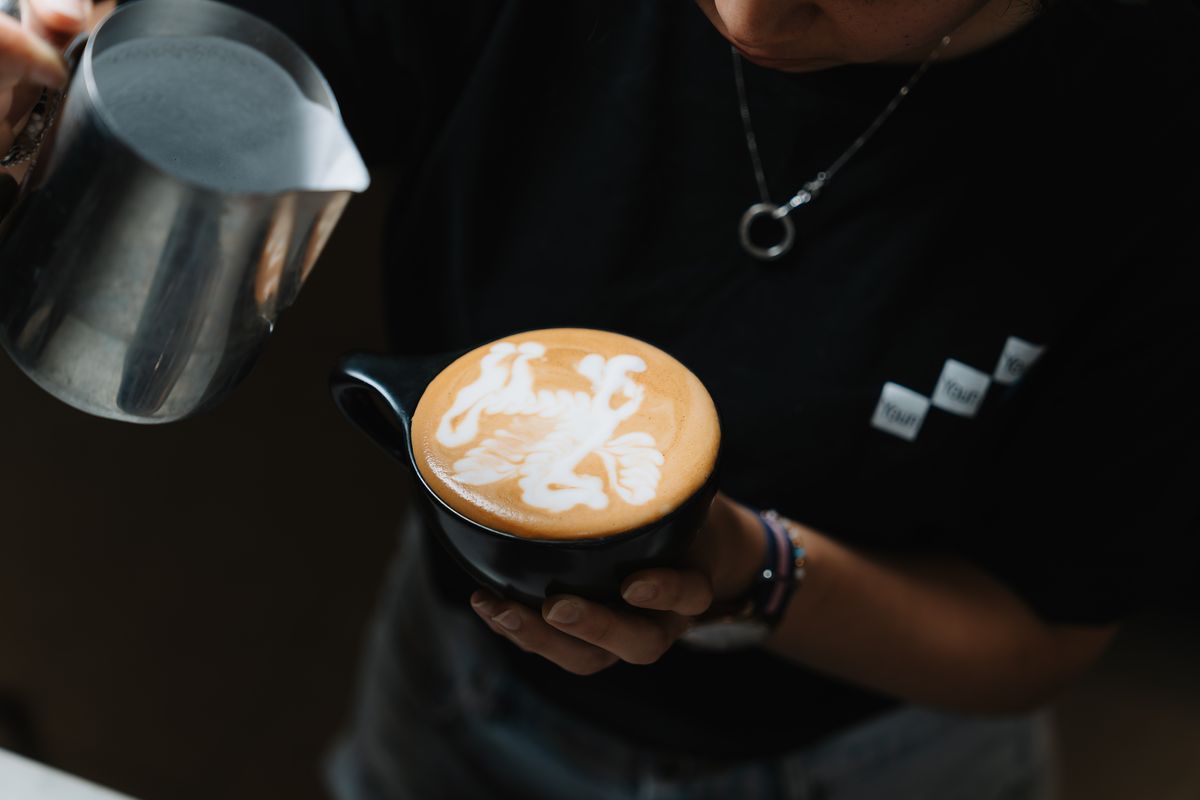 A barista pouring latte art at Momento Café