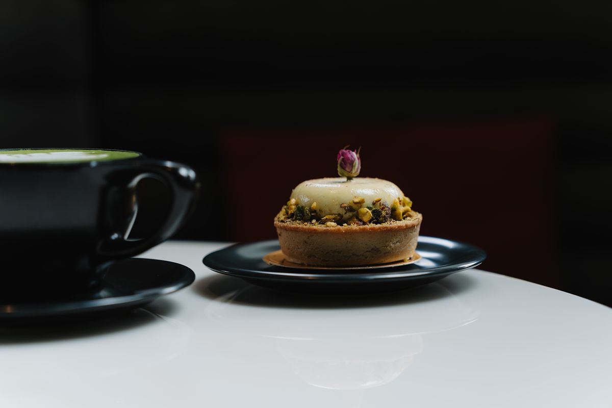 A pastry and a matcha latte on a marble table